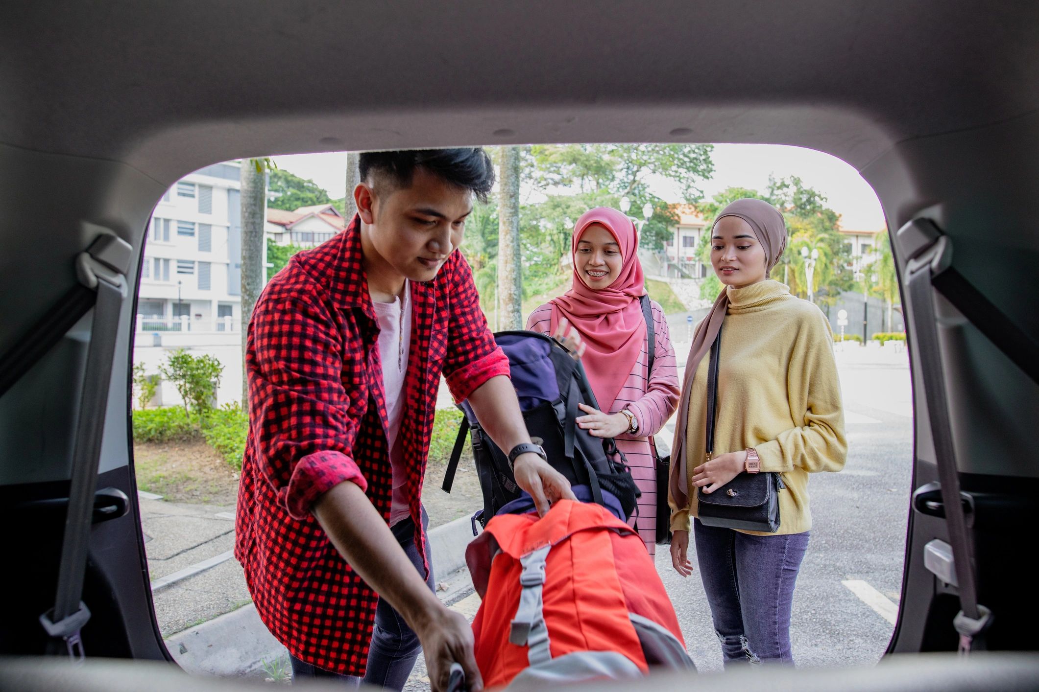 Friends unloading gear from a vehicle for an outdoor trip