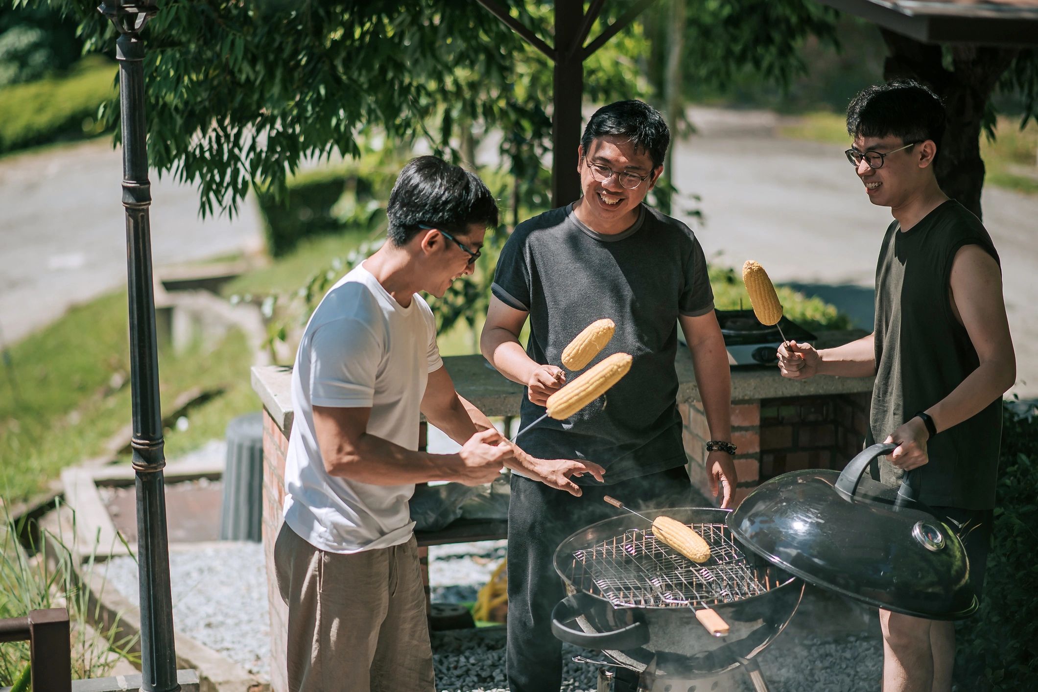 Friends grilling corn outdoors for a game-day gathering