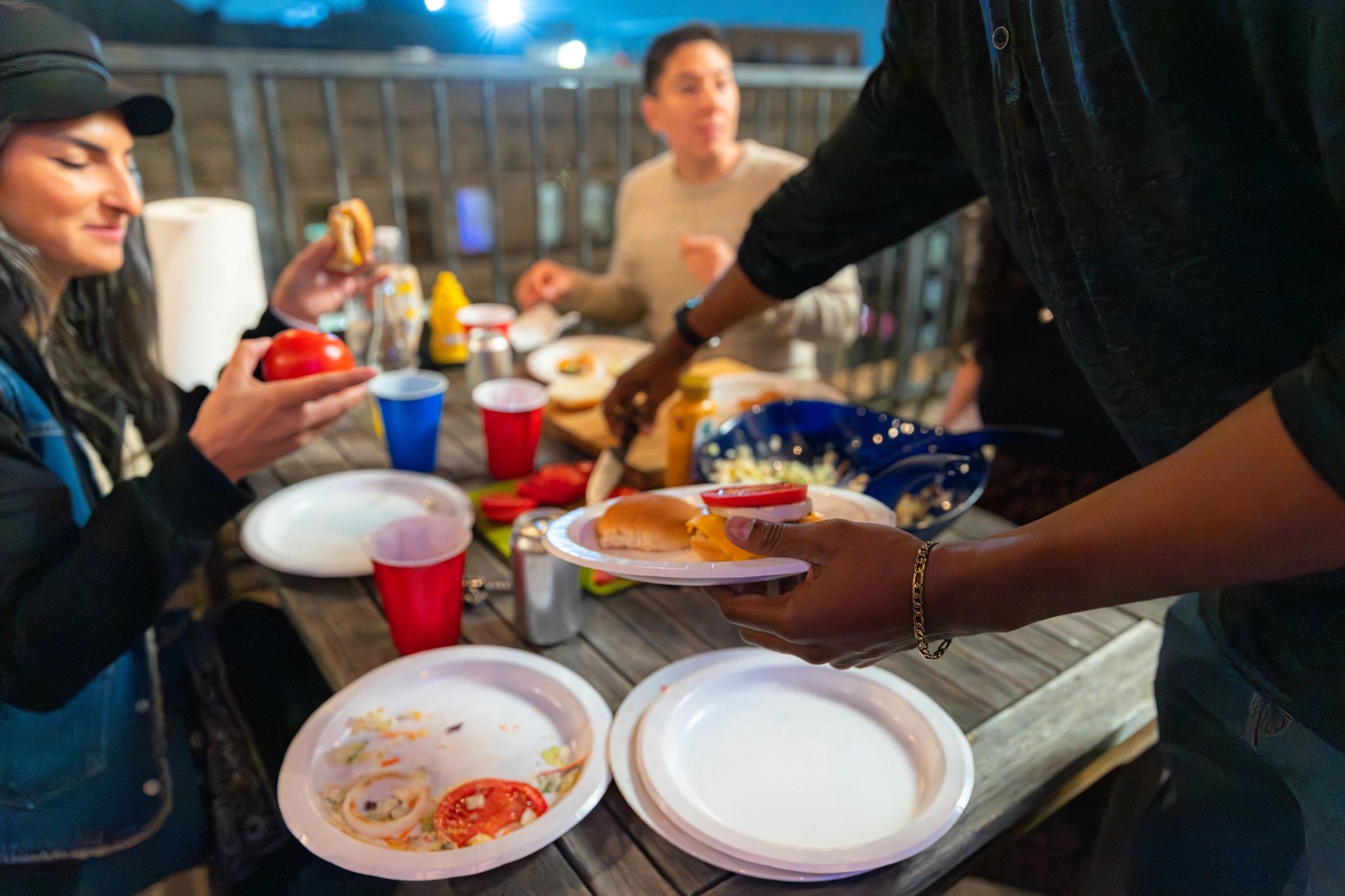 Friends sharing burgers and sides at an outdoor gathering