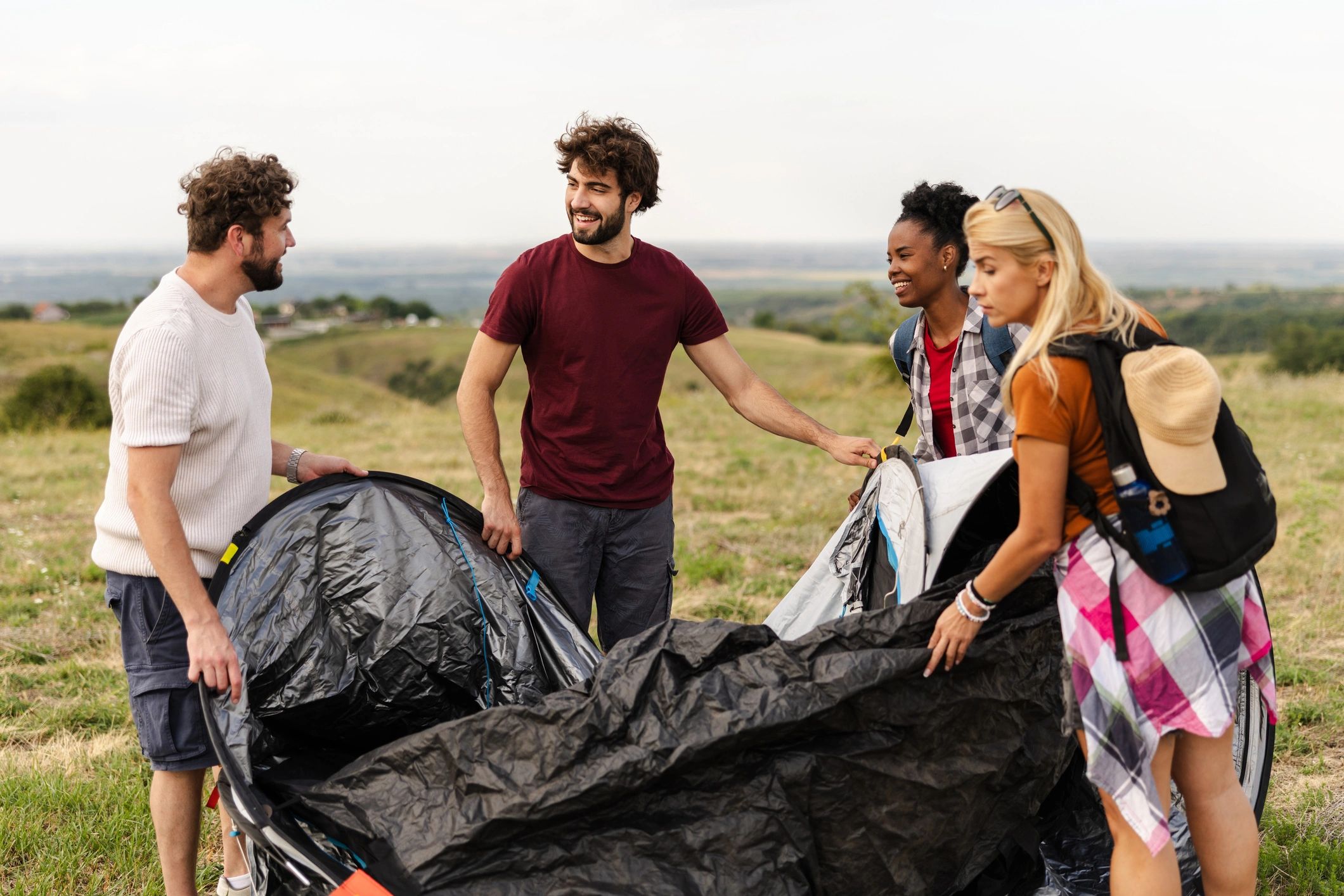 Friends setting up a tent outdoors