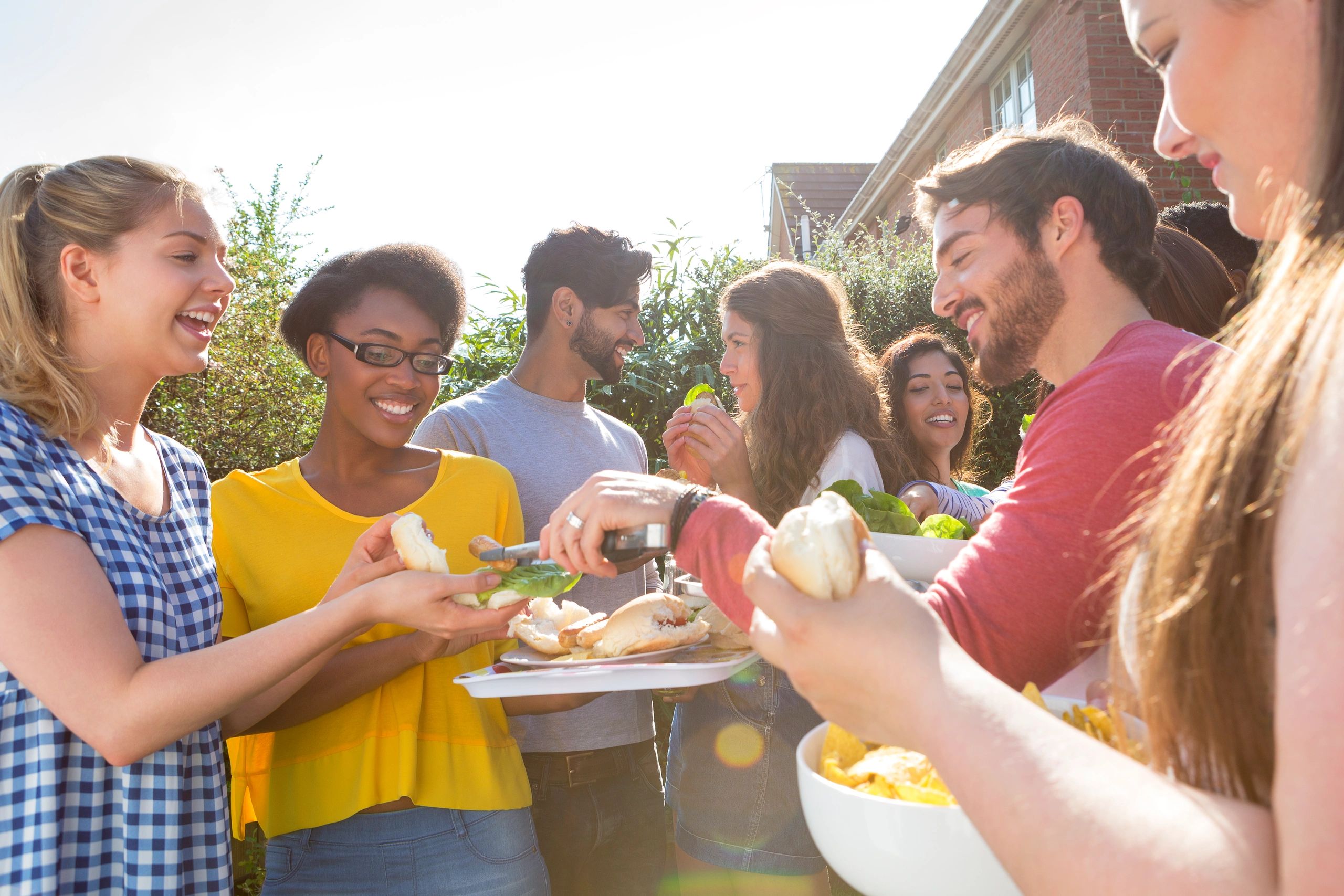 Friends enjoying food at an outdoor barbecue gathering